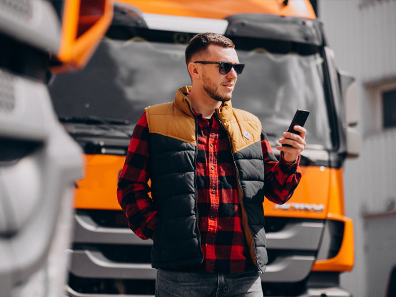 Ragazzo che lavoro in ambito logistico utilizza smartphone e la app lolyo per comunicare